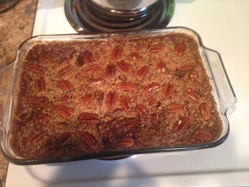 A pan of pecan cobbler. It has a fluffy texture, and a crunchy taste due to the crust and pecans in the filling and on top. 