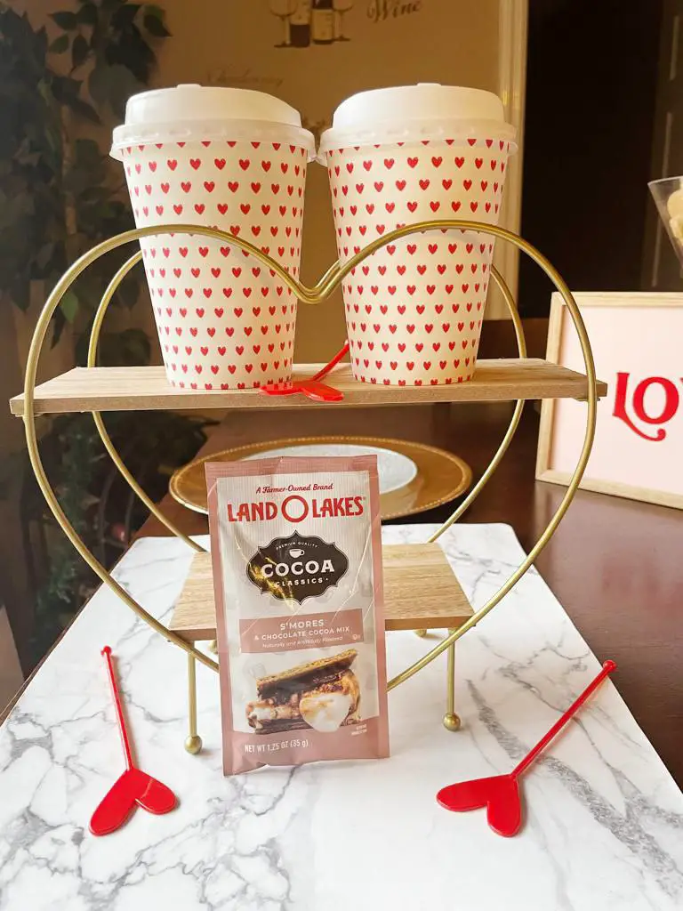 Colorful handmade Valentine's day gift that contains paper cups with red hearts and hot coca powder on a charming wooden stand formed like a heart for super Valentine Gift DIY ideas.