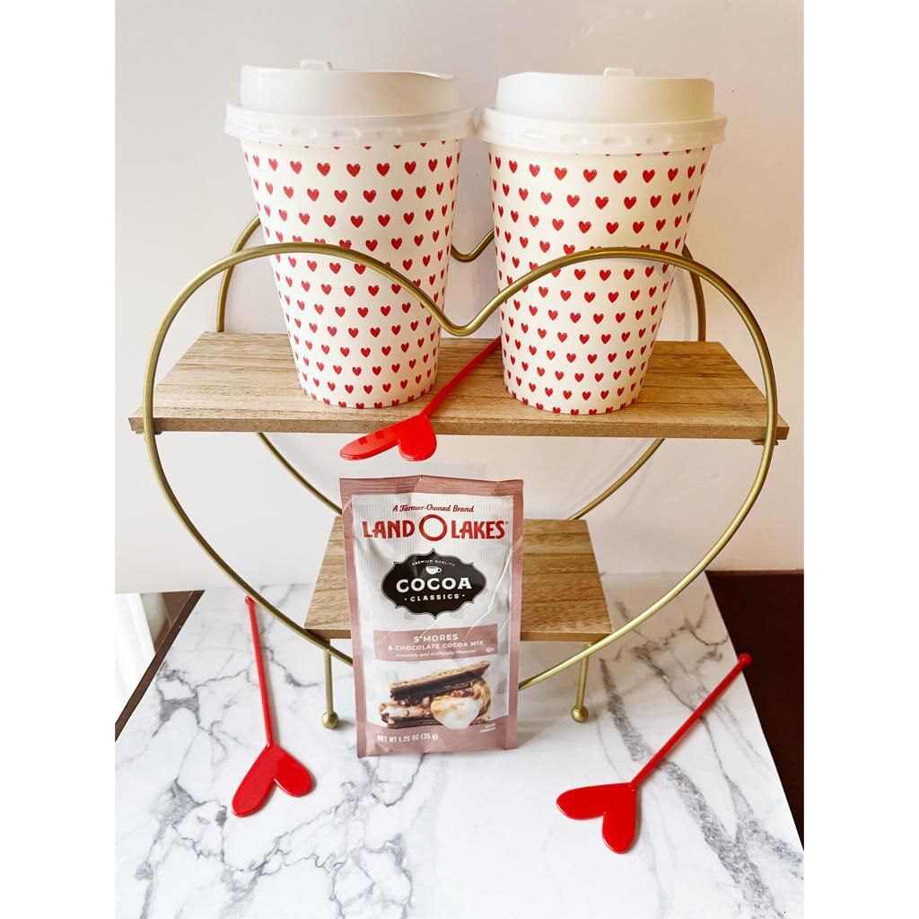 Cute paper coffee cups with heart prints and some delightful Land O Lakes  S'mores and chocolate coca mix powder to add, placed on an elegant heart stand made of wood. Perfect Valentine Gift DIY ideas.