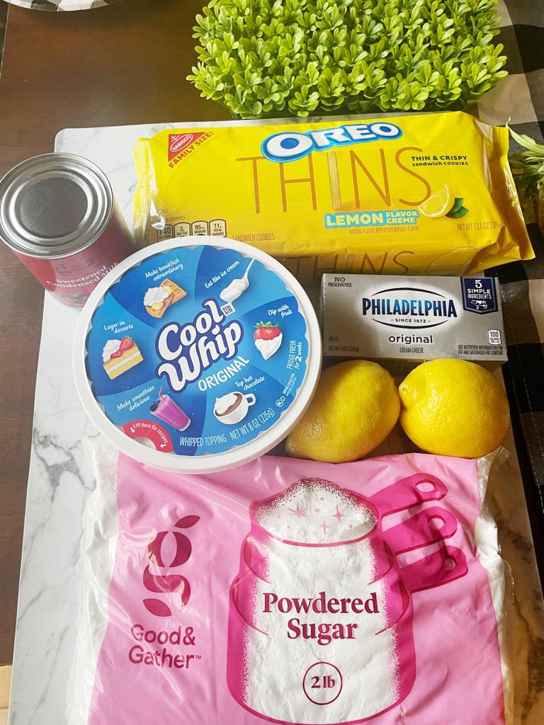 lemon pudding ingredients: oreo lemon thins, philadelphia cream cheese, sweetened condensed milk, cool whip, powdered sugar, and lemons.