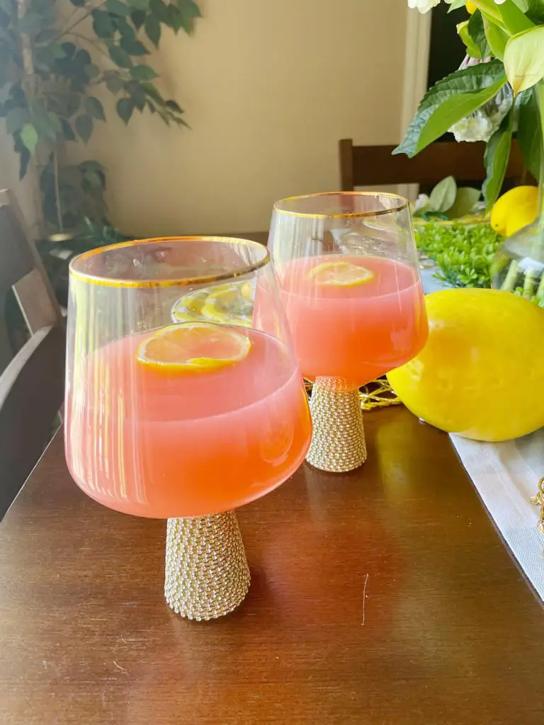 This refreshing pink lemonade recipe requires only sugar, pineapple juice, country time lemonade, a can of pineapple chunks and juice, and lemon. A delightful lemonade punch produced with love is perfect for the whole family.