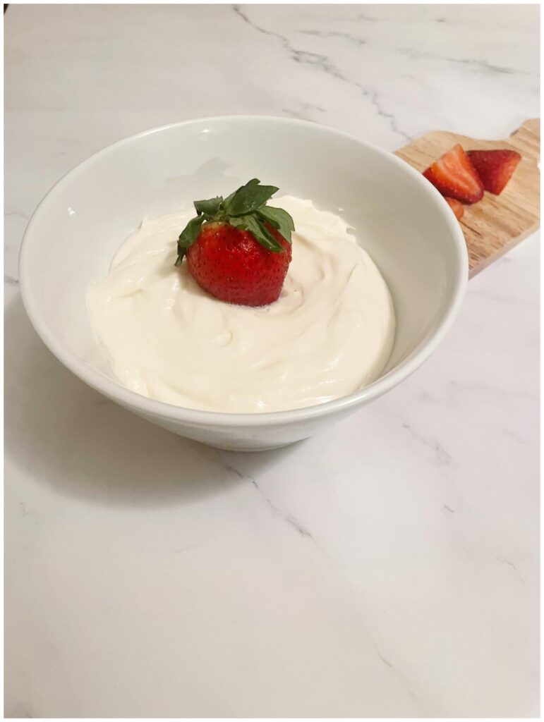 fruit dip in white bowl with strawberry in the center